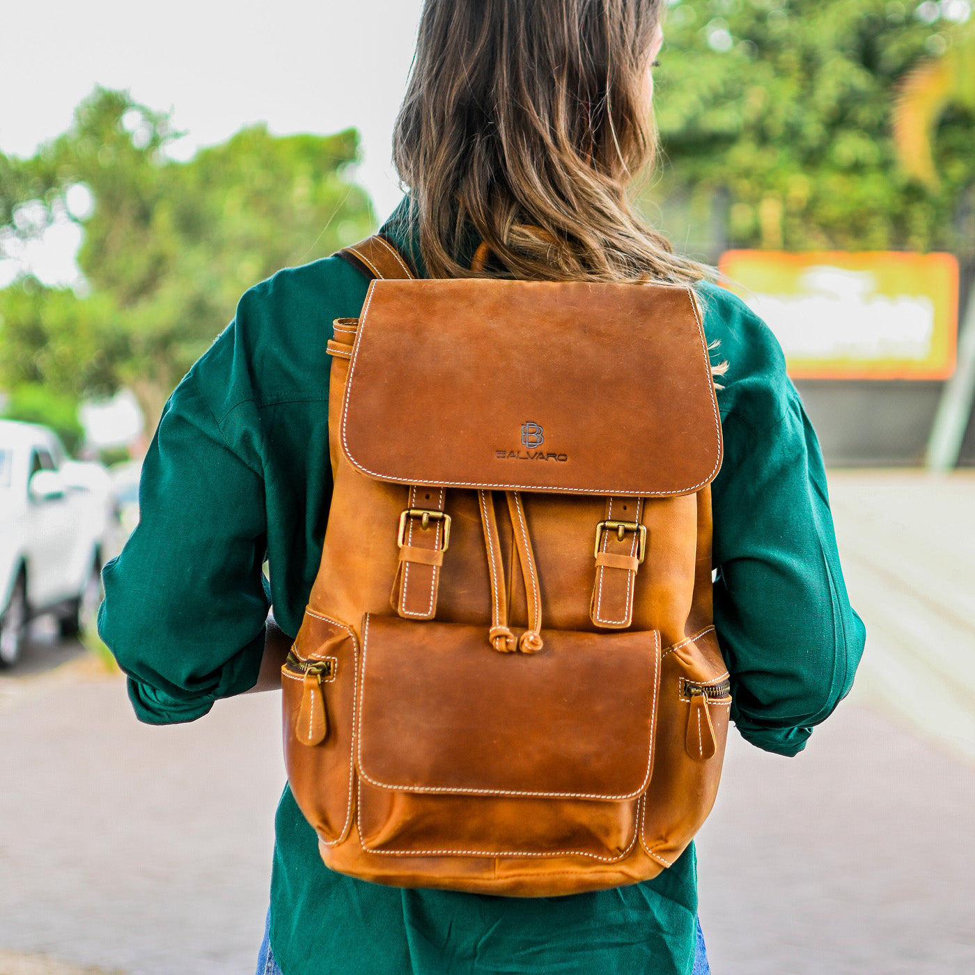Person wearing a brown leather backpack outdoors